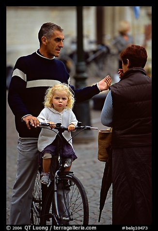 Blond little girl sitting on bicycle. Bruges, Belgium