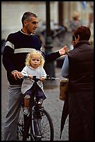 Blond little girl sitting on bicycle. Bruges, Belgium (color)