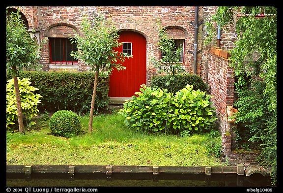 Small garden and brick house by the canal. Bruges, Belgium
