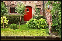 Small garden and brick house by the canal. Bruges, Belgium