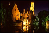 Old houses and beffroi reflected in canal at night. Bruges, Belgium