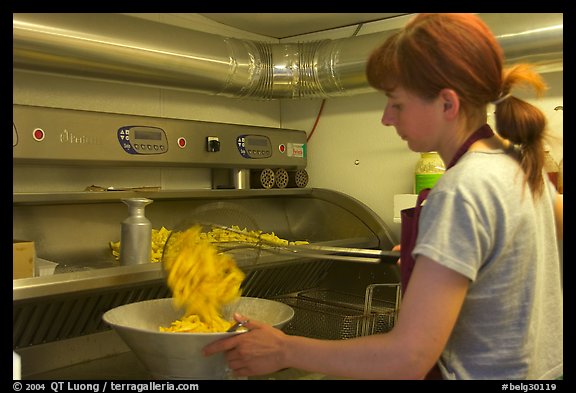 Woman cooking fries in a booth. Bruges, Belgium