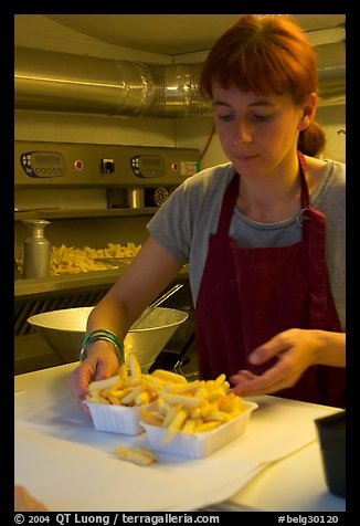 Woman serving fries in a booth. Bruges, Belgium