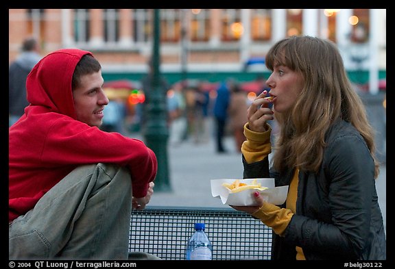 Young woman eating fries, Markt. Bruges, Belgium (color)