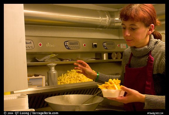 Woman preparing fries in a booth. Bruges, Belgium (color)
