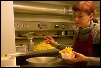 Woman preparing fries in a booth. Bruges, Belgium (color)