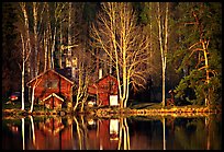 Wooden house reflected in a lake at sunset. Central Sweden