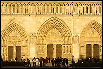 People standing in front of gates of Notre Dame Cathedral, late afternoon. Paris, France