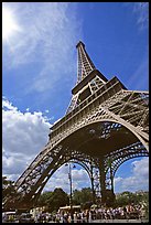 Eiffel tower and sun with crowds at base. Paris, France