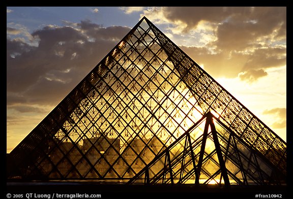 Sunset and clouds seen through Pyramid, the Louvre. Paris, France