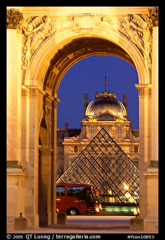 Louvre, pyramid, and bus seen through the Carousel Arch at night. Paris, France (color)