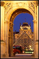 Louvre, pyramid, and bus seen through the Carousel Arch at night. Paris, France ( color)