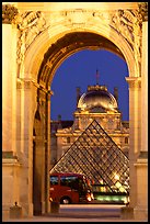 Louvre, pyramid, and bus seen through the Carousel Arch at night. Paris, France ( color)