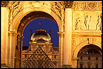 Louvre and  pyramid  seen through the Carousel triumphal arch at night. Paris, France ( color)