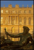 Statue, basin, and Versailles palace facade, late afternoon. France