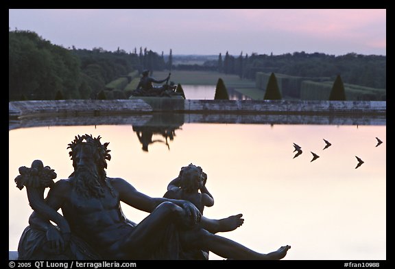 Sculptures, basin, and gardens at dusk, Palais de Versailles. France (color)