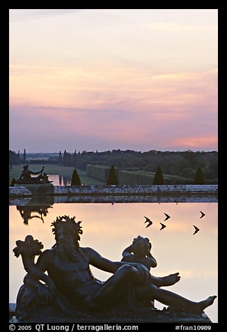 Sculptures, basin, and gardens at dusk, Versailles Palace. France