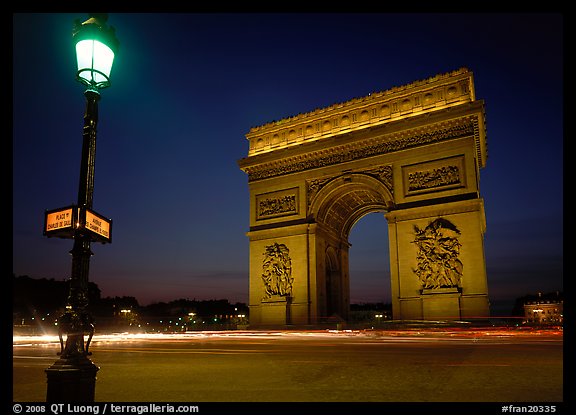 Street lamp and Etoile triumphal arch at night. Paris, France (color)