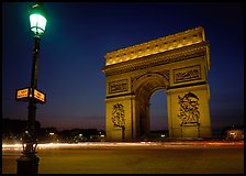 Street lamp and Etoile triumphal arch at night. Paris, France (color)