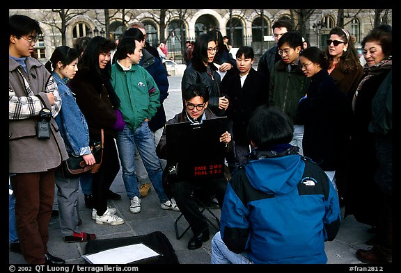 Sketch drawer surrounded by onlookers. Paris, France (color)