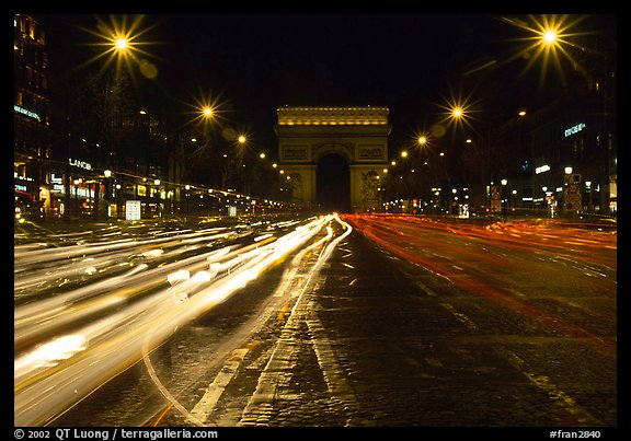 Arc de Triomphe seen from the middle of Champs Elysees at night. Paris, France