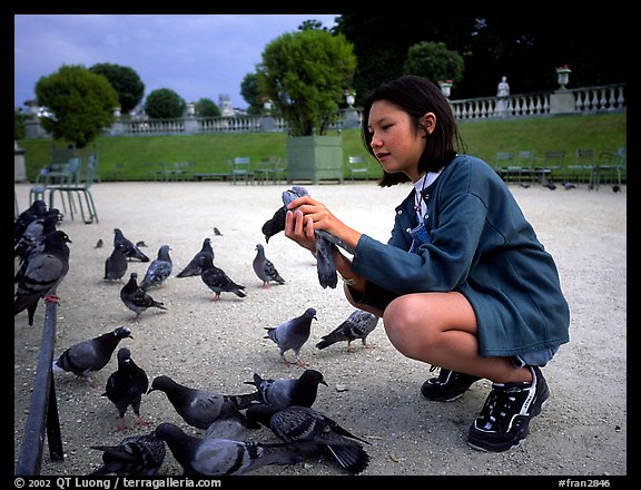 Girl feeding pigeon, Jardin du Luxembourg. Quartier Latin, Paris, France (color)