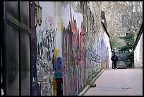 Boy in side alley with graffiti on walls. Paris, France