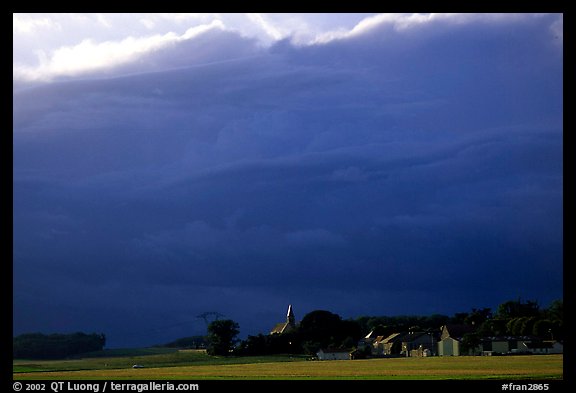 Stormy skies and village. France