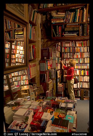 Picking-up a book in Shakespeare and Co bookstore. Quartier Latin, Paris, France (color)