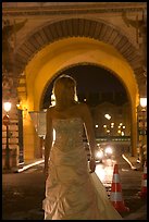 Woman in bridal gown in front of the Louvre by night. Paris, France