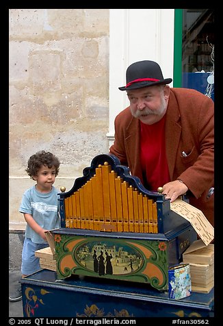 Barrel organ player and kid. Quartier Latin, Paris, France (color)