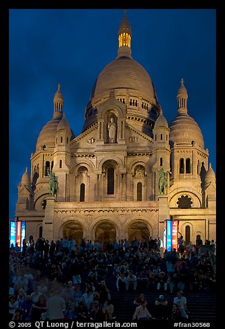 Tourists sitting on the stairs of the Sacre coeur basilic in Montmartre at night. Paris, France (color)