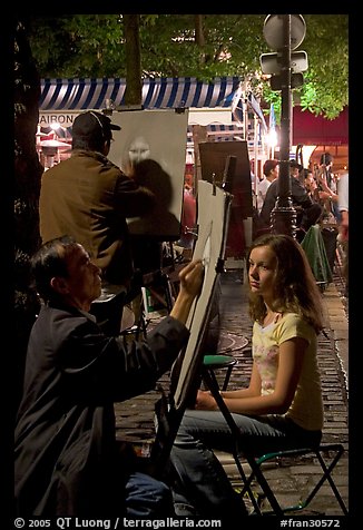 Artists drawing portraits at night on the Place du Tertre, Montmartre. Paris, France (color)