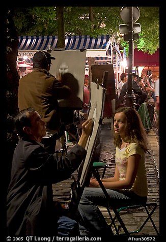 Artists drawing portraits at night on the Place du Tertre, Montmartre. Paris, France