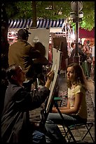 Artists drawing portraits at night on the Place du Tertre, Montmartre. Paris, France