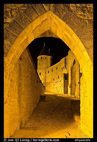 Ramparts and tower framed by gate at night. Carcassonne, France