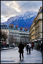 Downtown street and snowy mountains of the Belledone Range. Grenoble, France