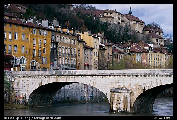 Stone bridge and brightly painted riverside townhouses. Grenoble, France