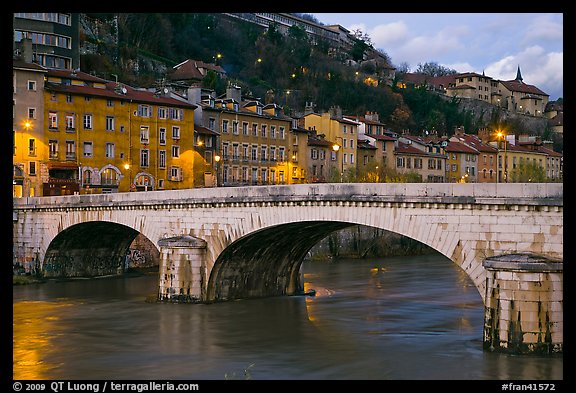 Bridge and brightly painted riverside houses at dusk. Grenoble, France