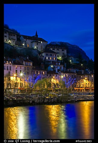 Hillside houses and Christmas lights reflected in Isere River. Grenoble, France