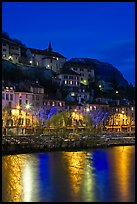 Hillside houses and Christmas lights reflected in Isere River. Grenoble, France
