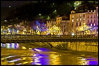 Suspension bridge at night with Christmas lights reflected in river. Grenoble, France (color)