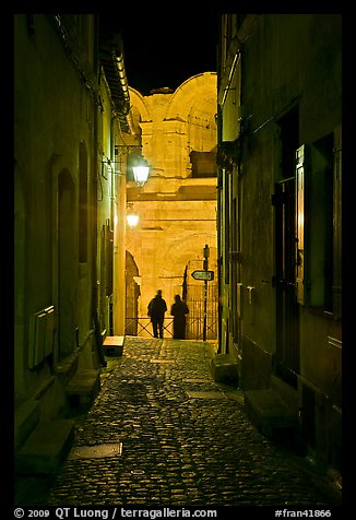 Narrow cobblestone passageway at night next to arena. Arles, Provence, France