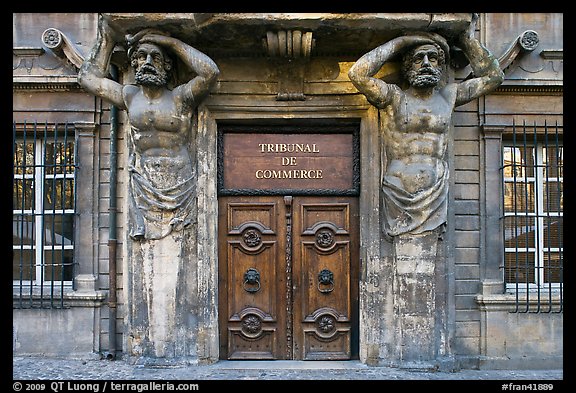 Wooden door framed by sculptures. Aix-en-Provence, France