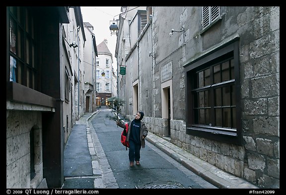 Boy walking in narrow street, Chartres. France