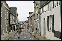 Pedestrian with umbrella in narrow street, Provins. France ( color)