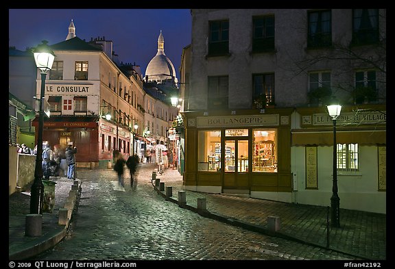 Cobblestone street, lamps, and Sacre-Coeur basilica by night, Montmartre. Paris, France (color)