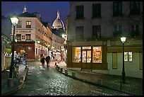 Cobblestone street, lamps, and Sacre-Coeur basilica by night, Montmartre. Paris, France (color)