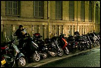 Scooters parked on a sidewalk at night. Paris, France