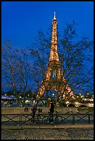 Bicyclists and Eiffel tower at night. Paris, France